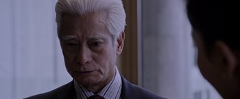 Movie still from “The Martian” (2015), directed by Ridley Scott – An older man in a suit and tie looking sad; Close Up shot, Over the shoulder angle
