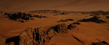 Movie still from “The Martian” (2015), directed by Ridley Scott – An aerial view of a desert with mountains in the background; Extreme Wide shot, High angle