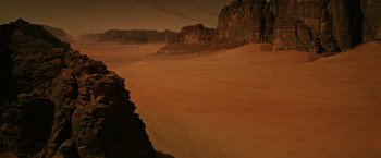 Movie still from “The Martian” (2015), directed by Ridley Scott – A sandy beach with a mountain in the background; Extreme Wide shot, High angle