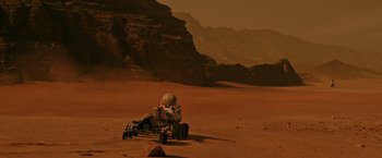 Movie still from “The Martian” (2015), directed by Ridley Scott – A person on a buggy in the middle of the desert; Extreme Wide shot, High angle