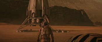 Movie still from “The Martian” (2015), directed by Ridley Scott – An astronaut is standing on the surface of an exoplanet; Wide shot, Over the shoulder angle