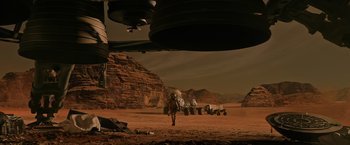 Movie still from “The Martian” (2015), directed by Ridley Scott – A man walking across a dirt field next to rocks; Extreme Wide shot, Low angle