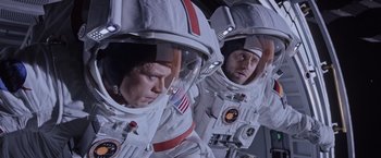 Movie still from “The Martian” (2015), directed by Ridley Scott – Two men in spacesuits are reflected in a mirror; Medium shot, Overhead angle