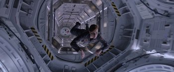 Movie still from “The Martian” (2015), directed by Ridley Scott – A man in a space suit hanging in a space station; Wide shot, Overhead angle