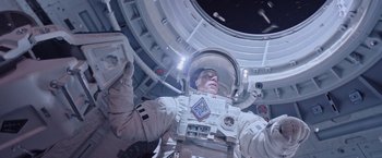 Movie still from “The Martian” (2015), directed by Ridley Scott – A man in a spacesuit is holding a remote control; Medium shot, Overhead angle