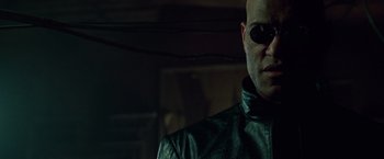 Movie still from “The Matrix” (1999), directed by Lana Wachowski – A person wearing a leather jacket; Close Up shot, Low angle