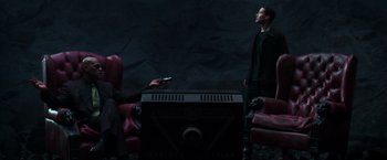 Movie still from “The Matrix” (1999), directed by Lana Wachowski – A man and a woman are playing a video game; Wide shot, High angle