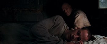 Movie still from “The Matrix” (1999), directed by Lana Wachowski – A man and a woman laying on a bed in a dark room; Medium shot, High angle