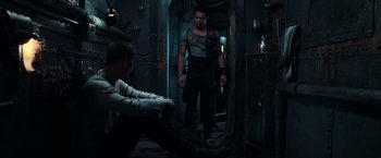 Movie still from “The Matrix” (1999), directed by Lana Wachowski – A man and a woman are standing in a room; Medium shot, High angle