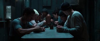 Movie still from “The Matrix” (1999), directed by Lana Wachowski – A group of people sitting around a table; Medium shot, High angle