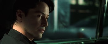Movie still from “The Matrix” (1999), directed by Lana Wachowski – A man's face in front of a window; Close Up shot, Over the shoulder angle