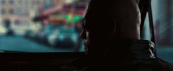 Movie still from “The Matrix” (1999), directed by Lana Wachowski – A man sitting in a car looking out the window at night; Close Up shot, Over the shoulder angle