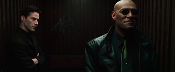 Movie still from “The Matrix” (1999), directed by Lana Wachowski – A bald man in a black leather jacket; Close Up shot, Low angle