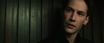 Movie still from “The Matrix” (1999), directed by Lana Wachowski – A person wearing a black shirt; Close Up shot, Low angle