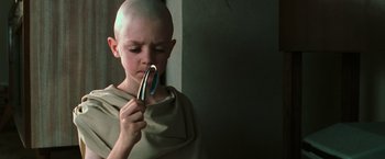 Movie still from “The Matrix” (1999), directed by Lana Wachowski – A young bald boy looking into a mirror; Close Up shot, Low angle