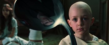 Movie still from “The Matrix” (1999), directed by Lana Wachowski – A young bald boy is looking into a mirror; Close Up shot, High angle