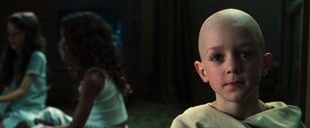 Movie still from “The Matrix” (1999), directed by Lana Wachowski – A young boy with a shaved head and a little girl with blue eyes; Close Up shot, High angle