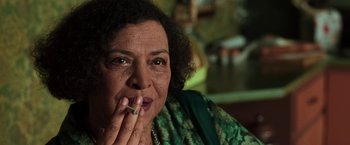 Movie still from “The Matrix” (1999), directed by Lana Wachowski – An older woman is smoking a cigarette and looking at the camera; Close Up shot, Low angle