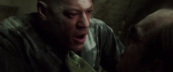 Movie still from “The Matrix” (1999), directed by Lana Wachowski – A person wearing a green tie; Close Up shot, High angle