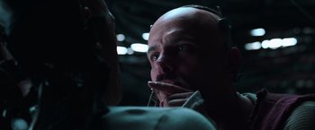 Movie still from “The Matrix” (1999), directed by Lana Wachowski – A man with a bald head is talking to another man; Close Up shot, Over the shoulder angle