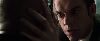 Movie still from “The Matrix” (1999), directed by Lana Wachowski – A person talking on a cell phone; Close Up shot, Over the shoulder angle