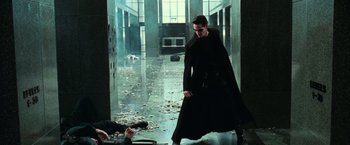 Movie still from “The Matrix” (1999), directed by Lana Wachowski – A man in a black robe walking down a hall way; Wide shot, Low angle