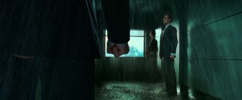 Movie still from “The Matrix” (1999), directed by Lana Wachowski – A man in a suit and tie standing in front of two other men; Medium shot, Low angle