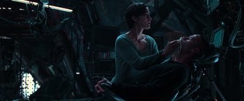 Movie still from “The Matrix” (1999), directed by Lana Wachowski – A woman sitting on the ground in a dark room; Medium shot, High angle