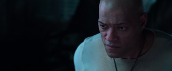 Movie still from “The Matrix” (1999), directed by Lana Wachowski – A man with bald head looking at the camera; Close Up shot, Low angle