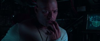 Movie still from “The Matrix” (1999), directed by Lana Wachowski – A bald man with his hand under his chin; Close Up shot, High angle
