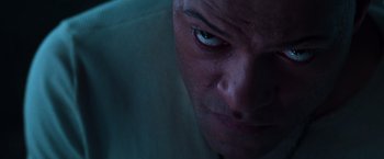 Movie still from “The Matrix” (1999), directed by Lana Wachowski – A man's face in a dark room; Extreme Close Up shot, Overhead angle