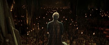 Movie still from “The Matrix Reloaded” (2003), directed by Lana Wachowski – An old man is standing in front of a group of people; Wide shot, High angle