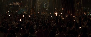 Movie still from “The Matrix Reloaded” (2003), directed by Lana Wachowski – A large crowd of people are gathered in the dark to watch a performance; Extreme Wide shot, High angle