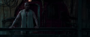 Movie still from “The Matrix Reloaded” (2003), directed by Lana Wachowski – A man standing next to a railing in front of a building; Medium shot, Low angle