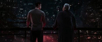 Movie still from “The Matrix Reloaded” (2003), directed by Lana Wachowski – Two people looking out of a window at a city skyline; Medium shot, Over the shoulder angle