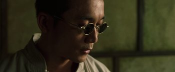 Movie still from “The Matrix Reloaded” (2003), directed by Lana Wachowski – A person wearing a pair of glasses; Close Up shot, Low angle