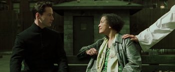 Movie still from “The Matrix Reloaded” (2003), directed by Lana Wachowski – Two people standing next to each other near a building; Close Up shot, Over the shoulder angle