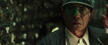 Movie still from “The Matrix Reloaded” (2003), directed by Lana Wachowski – A person wearing glasses and a hat; Close Up shot, Low angle