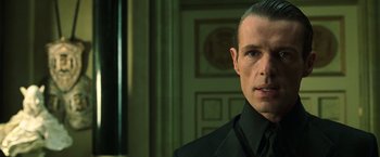 Movie still from “The Matrix Reloaded” (2003), directed by Lana Wachowski – A person wearing a suit and tie; Close Up shot, Low angle