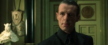 Movie still from “The Matrix Reloaded” (2003), directed by Lana Wachowski – A person wearing a suit and tie; Close Up shot, Low angle