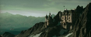 Movie still from “The Matrix Reloaded” (2003), directed by Lana Wachowski – A castle on top of a hill with a mountain in the background; Extreme Wide shot, Low angle