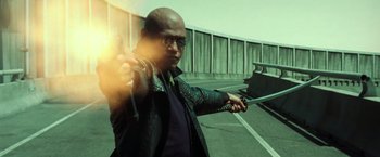 Movie still from “The Matrix Reloaded” (2003), directed by Lana Wachowski – A man holding a sword in his hands; Medium shot, Low angle