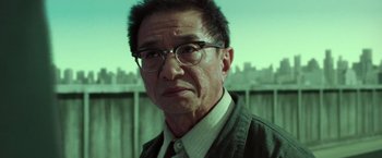 Movie still from “The Matrix Reloaded” (2003), directed by Lana Wachowski – An older man wearing glasses and a jacket; Close Up shot, Low angle