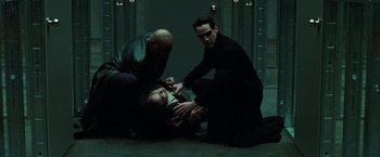 Movie still from “The Matrix Reloaded” (2003), directed by Lana Wachowski – A group of men in black shirts and ties; Medium shot, High angle