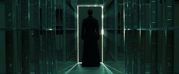 Movie still from “The Matrix Reloaded” (2003), directed by Lana Wachowski – A man standing in front of an open door; Wide shot, Low angle