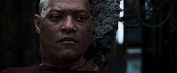 Movie still from “The Matrix Reloaded” (2003), directed by Lana Wachowski – A man's face in a dark room; Close Up shot, Low angle