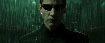 Movie still from “The Matrix Reloaded” (2003), directed by Lana Wachowski – A person wearing a suit and sunglasses; Close Up shot, Overhead angle