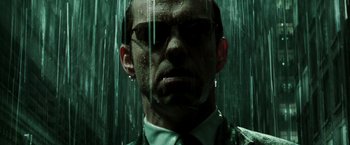 Movie still from “The Matrix Reloaded” (2003), directed by Lana Wachowski – A person wearing a suit and tie; Close Up shot, Low angle