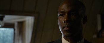 Movie still from “The Matrix Resurrections” (2021), directed by Lana Wachowski – A person wearing a suit and tie; Close Up shot, Low angle