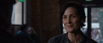 Movie still from “The Matrix Resurrections” (2021), directed by Lana Wachowski – A person wearing a black jacket; Close Up shot, Over the shoulder angle